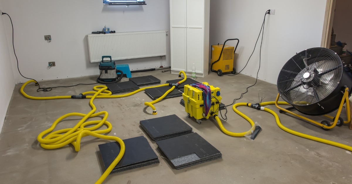 Technician performing professional flooded basement cleanup in Utah home.