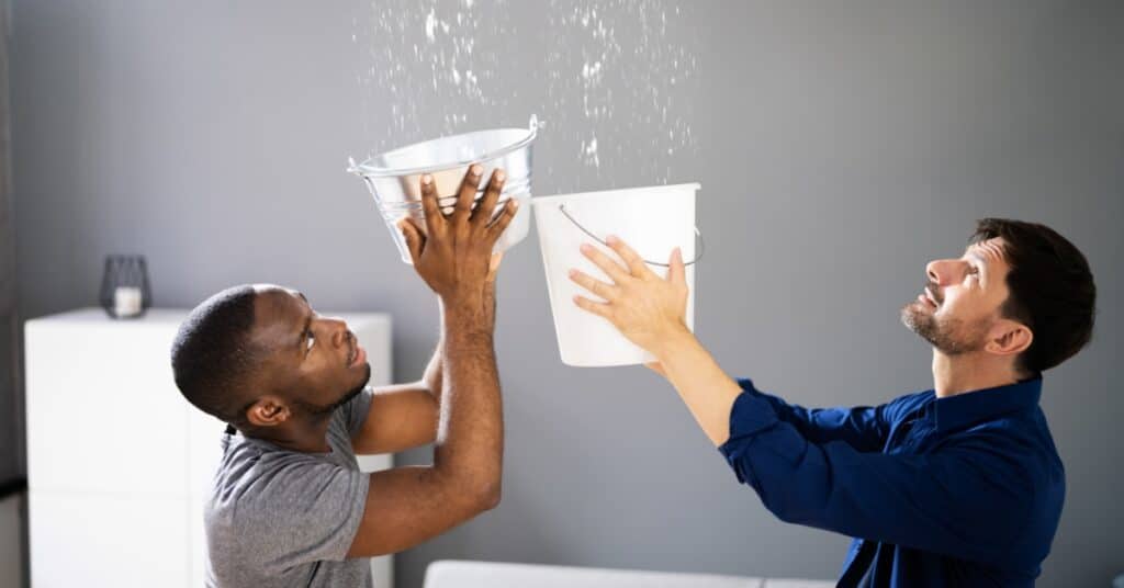 Technician inspecting ceiling water damage in a residential home